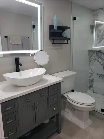 Guest bathroom vanity has vessel sink with lighted mirror