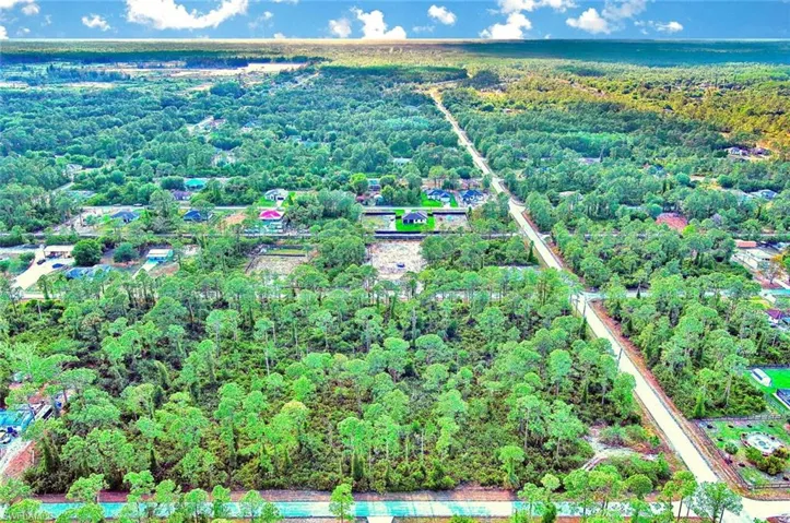 Aerial view of property and surrounding area featuring a forest