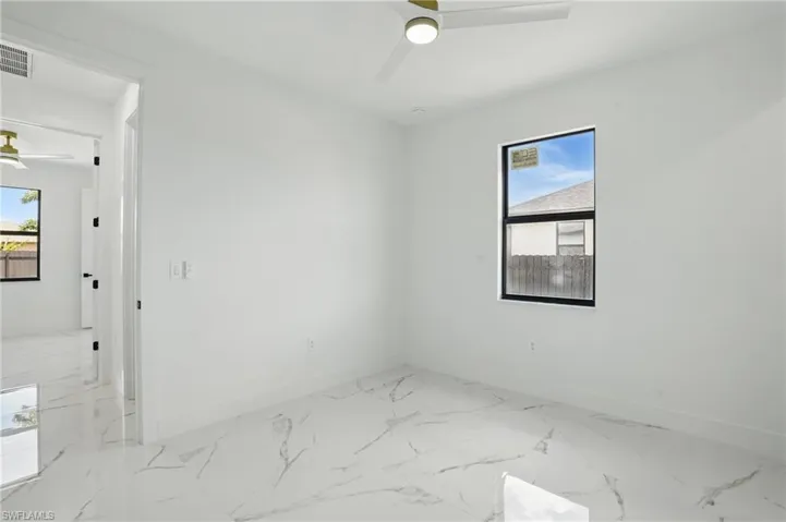 Empty room with ceiling fan, baseboards, and marble finish flooring