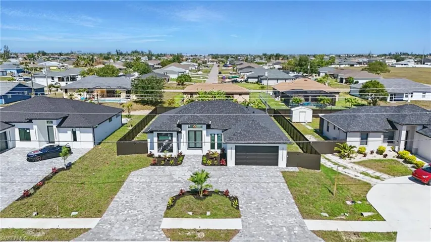 View of front of house with a residential view, decorative driveway, a garage, and a front lawn