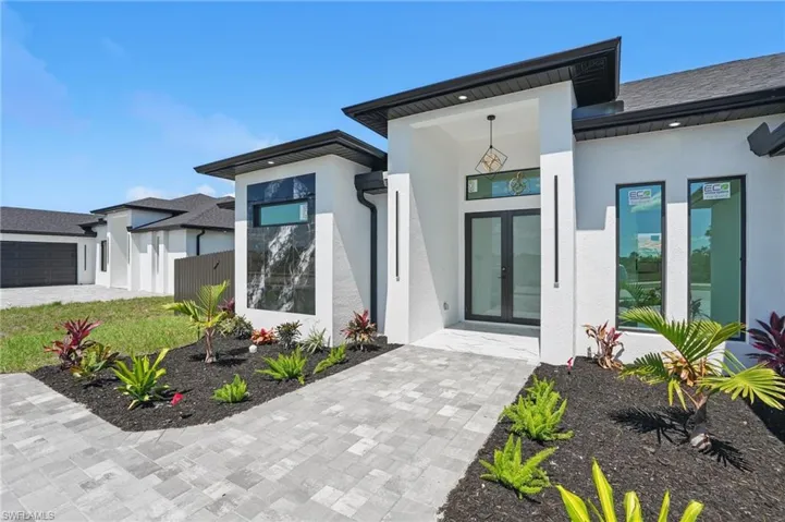 View of exterior entry featuring french doors and stucco siding