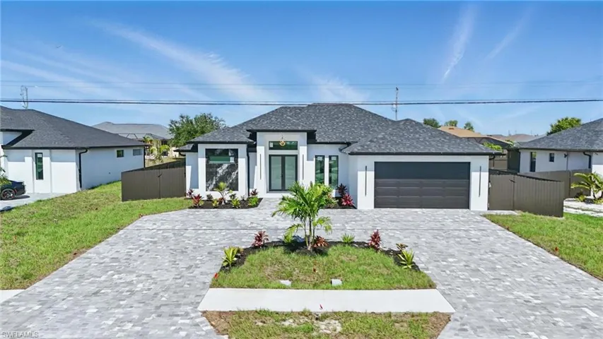 View of front of house featuring stucco siding, a garage, decorative driveway, and a shingled roof