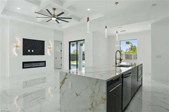 Kitchen with modern cabinets, open floor plan, a sink, coffered ceiling, and stainless steel dishwasher