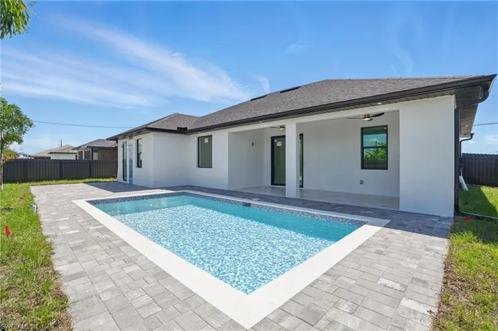 View of swimming pool featuring a patio area, fence, and ceiling fan