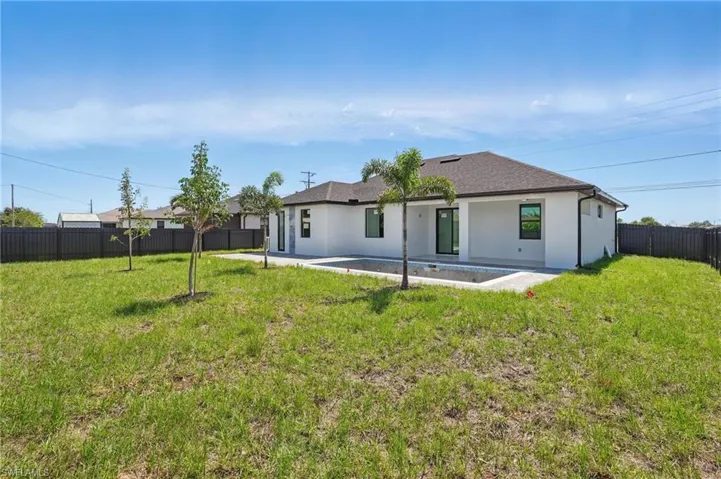 Rear view of property with a patio, stucco siding, and roof with shingles