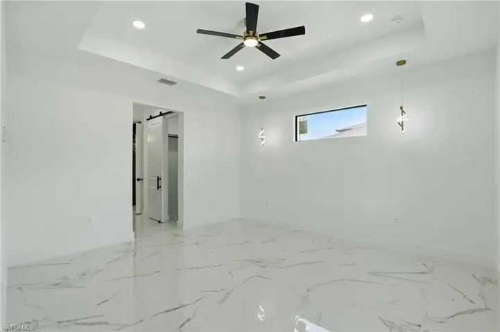 Empty room with baseboards, a tray ceiling, recessed lighting, a ceiling fan, and a smoke detector