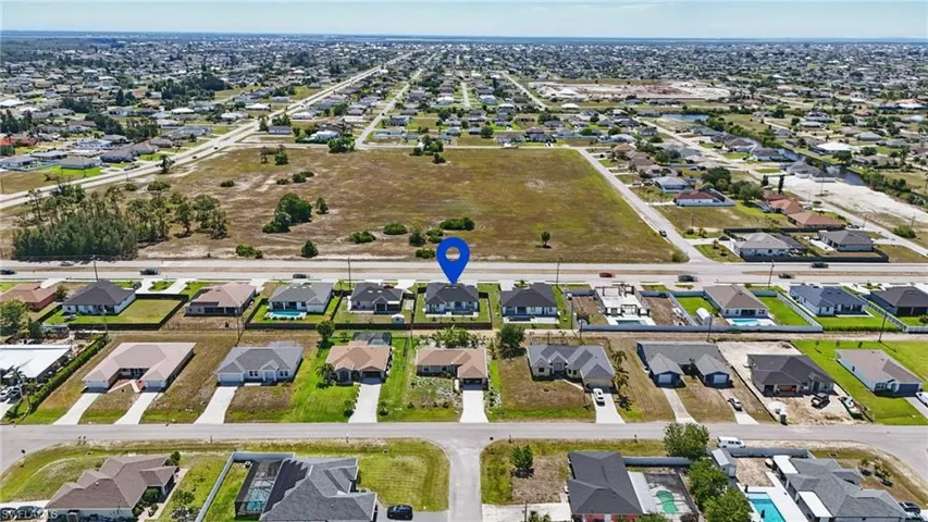 Aerial view of property and surrounding area with nearby suburban area