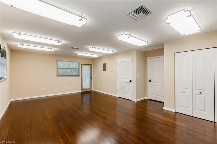 Empty room featuring dark hardwood / wood-style flooring