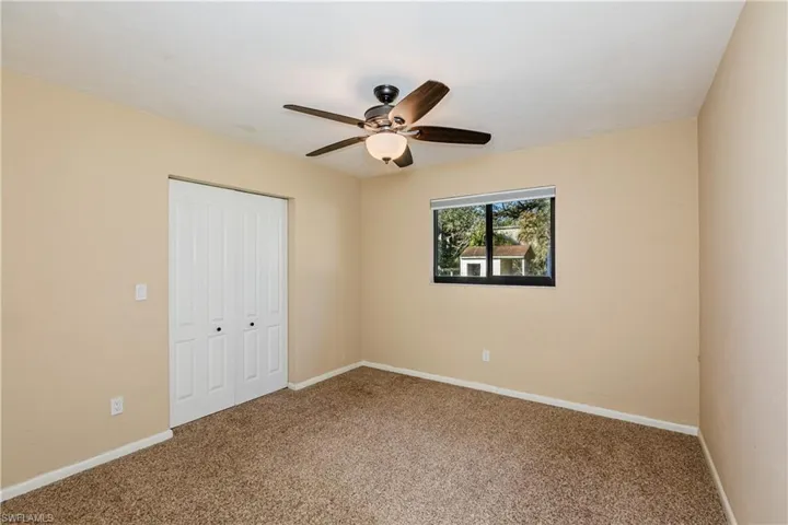 Unfurnished bedroom featuring ceiling fan, a closet, and carpet
