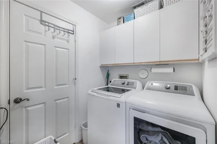 Laundry room with independent washer and dryer and cabinets