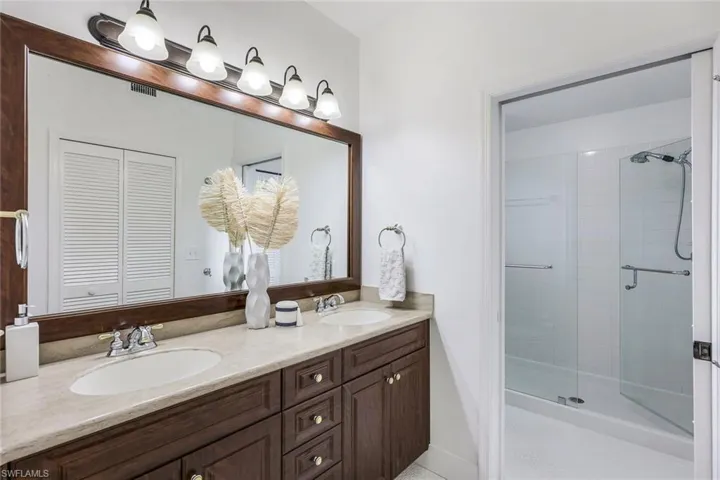 Bathroom featuring walk in shower and double sink vanity