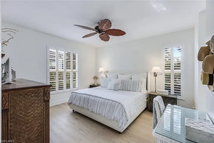 Bedroom with light hardwood / wood-style flooring, multiple windows, and ceiling fan