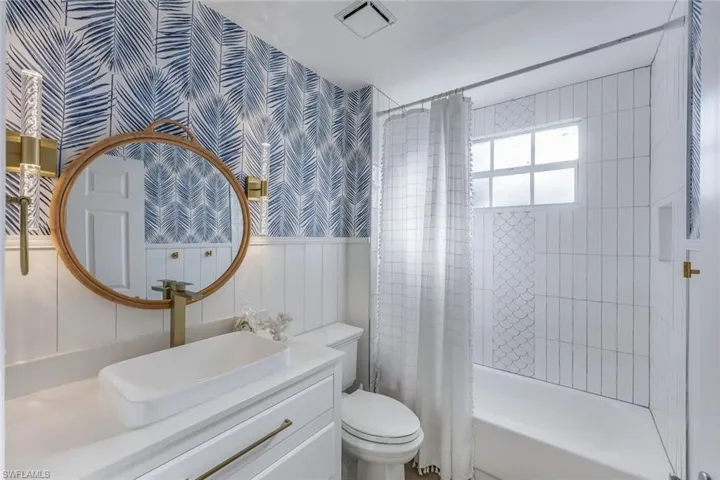 Full bathroom featuring vanity, toilet, and shower / bath combination with curtain