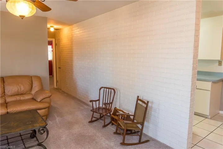 Living area with ceiling fan and light carpet