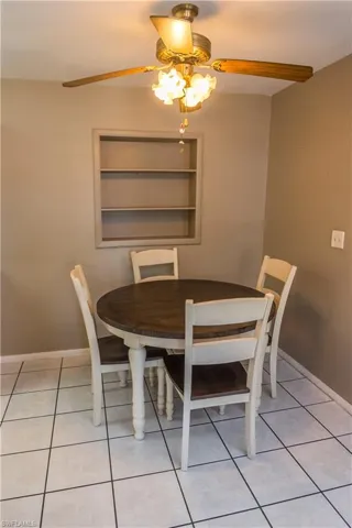 Dining area featuring light tile patterned floors, a ceiling fan, and built in features