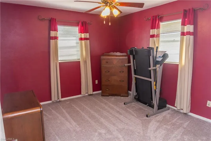 Workout room with light carpet and ceiling fan