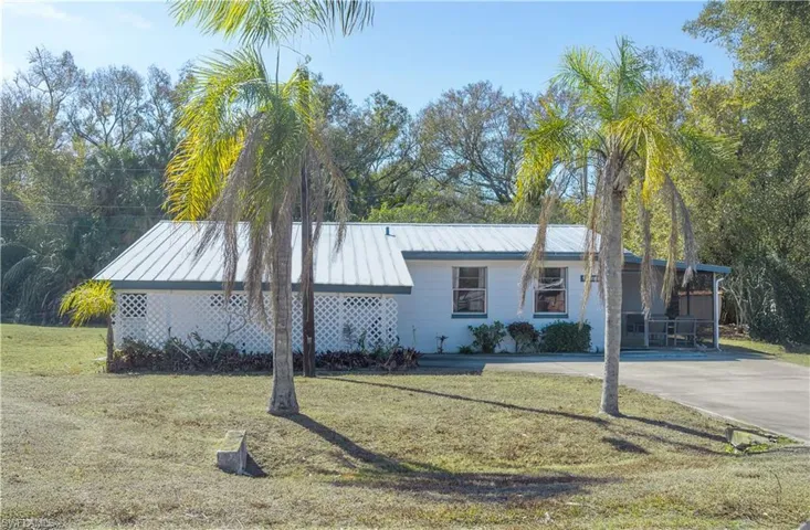 View of front of property featuring a front yard and a metal roof
