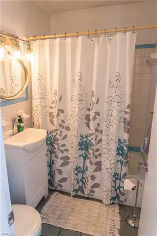 Full bath featuring vanity, shower / tub combo, and tile patterned floors