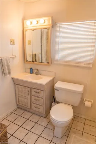 Half bathroom featuring vanity and light tile patterned flooring