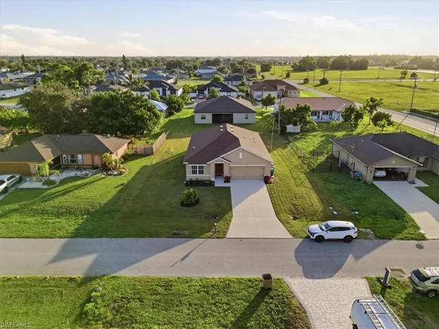 Single-story residence featuring a brown shingle roof, attached two-car garage, concrete driveway, and a manicured lawn