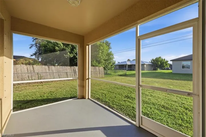 Screened patio with a painted concrete floor and a textured ceiling, overlooking a fenced backyard