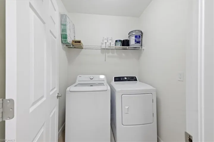 White laundry appliances, integrated wire shelving, and neutral wall finishes