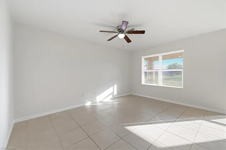 Tiled flooring, overhead ceiling fan with lighting, and a window with horizontal blinds
