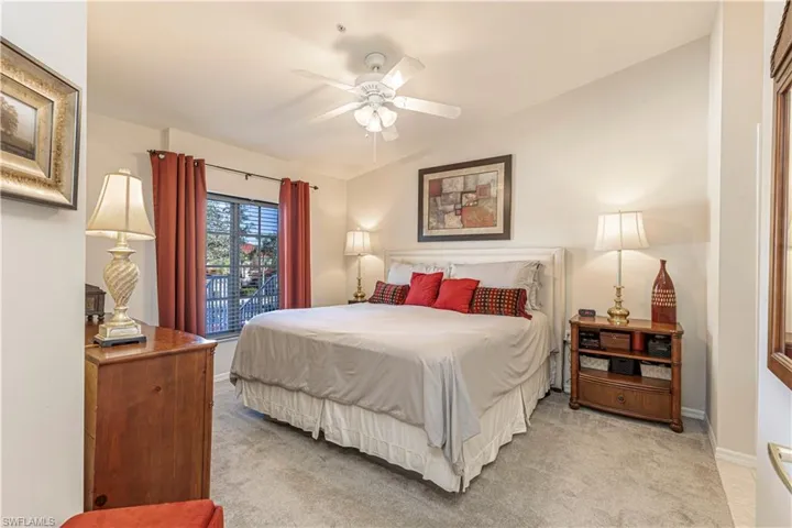 Bedroom featuring ceiling fan, lofted ceiling, and light carpet