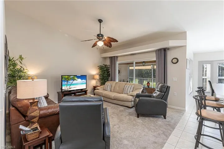 Living room featuring light tile patterned flooring, ceiling fan, and baseboards