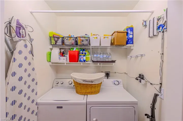 Ensuite Laundry area featuring washer and clothes dryer & storage racks