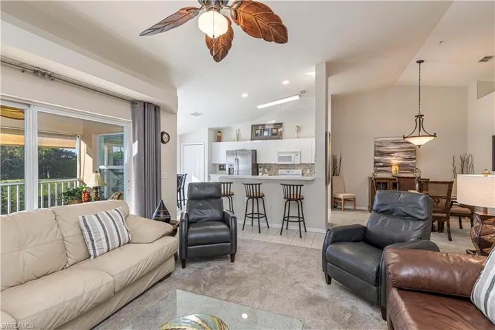 Living room featuring ceiling fan and lofted ceiling