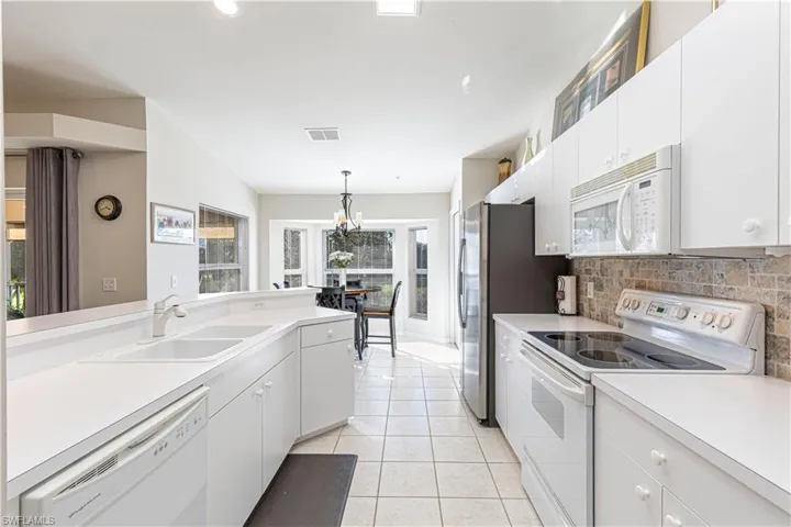 Large Chef's Kitchen with pendant lighting, white cabinetry.