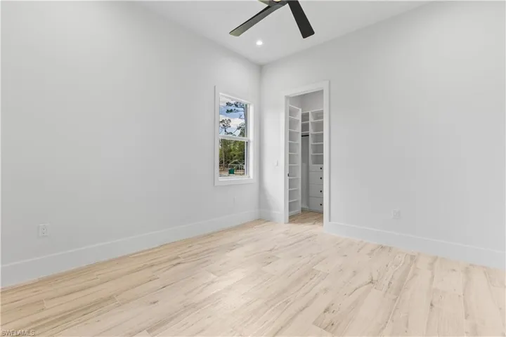 Unfurnished room with ceiling fan, wood finished floors, baseboards, and recessed lighting