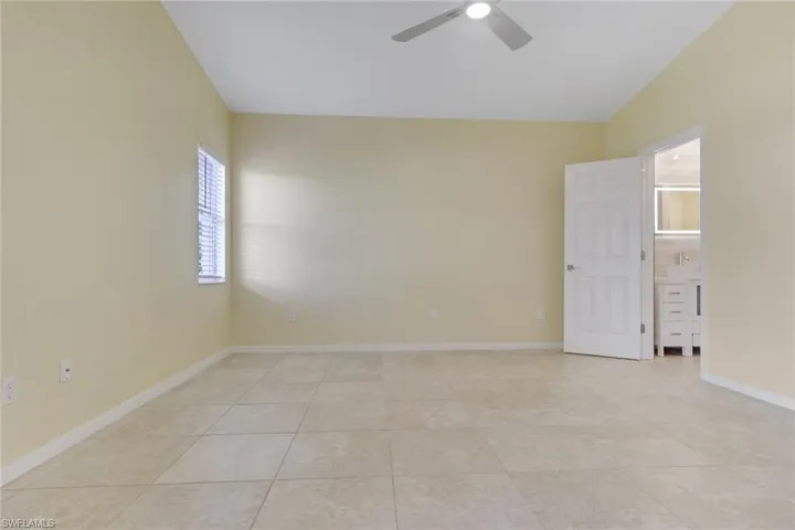 Spacious room featuring tile flooring, a window with horizontal blinds, and a ceiling fan