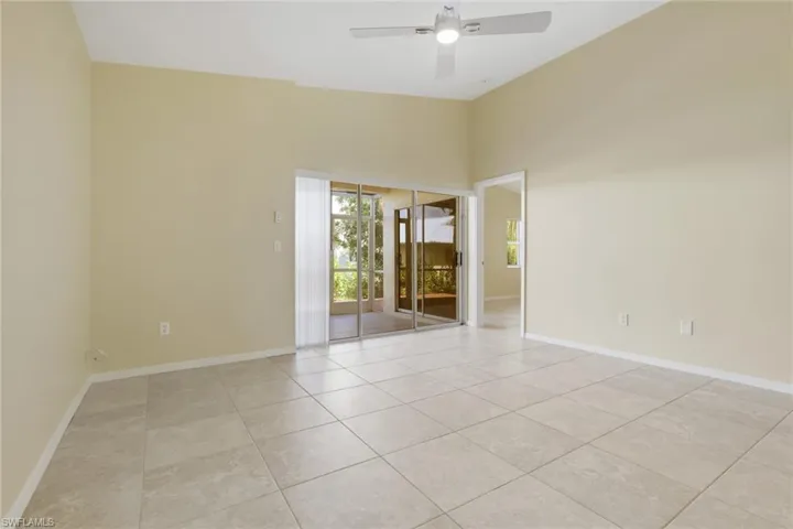 Spacious interior featuring neutral tile flooring and vaulted ceilings