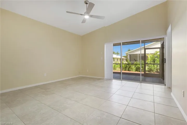 Spacious interior with vaulted ceilings, large format tile flooring, and a contemporary ceiling fan