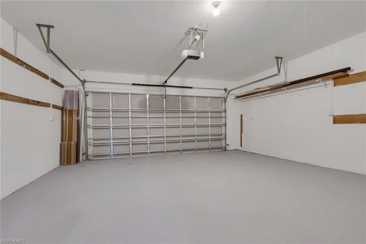 Spacious garage featuring a sectional garage door, painted concrete flooring, and an overhead lighting fixture