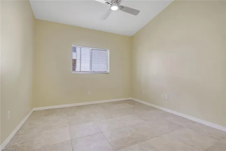 Room featuring vaulted ceilings and neutral-toned tile flooring