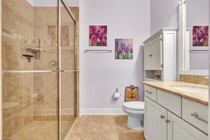 Full bath with vanity, a stall shower, and light tile patterned flooring