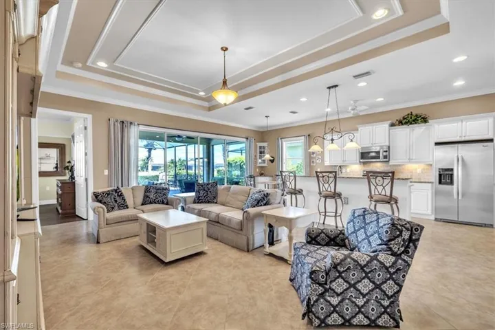 Living area with crown molding, a tray ceiling, and recessed lighting
