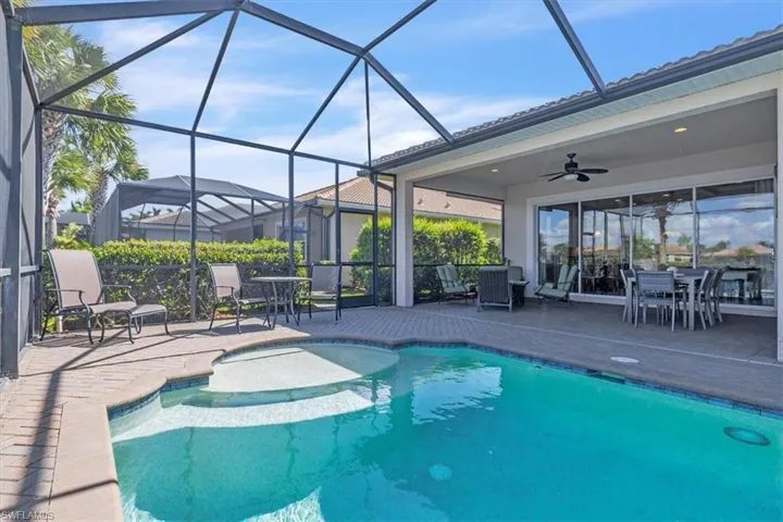 Outdoor pool featuring outdoor dining space, a sunroom, a patio, and a lanai