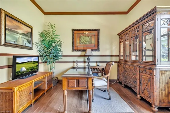 Office with crown molding and dark wood-style floors