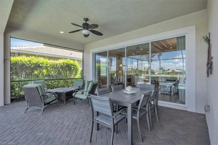 Sunroom / solarium with ceiling fan, a patio, and outdoor dining space