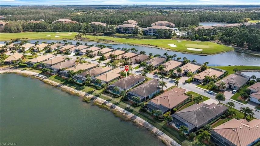 Aerial view of residential area with a golf course and a nearby body of water