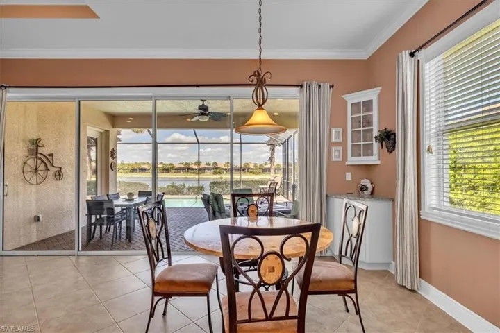 Dining room featuring crown molding, light tile patterned floors, ceiling fan, and a sunroom