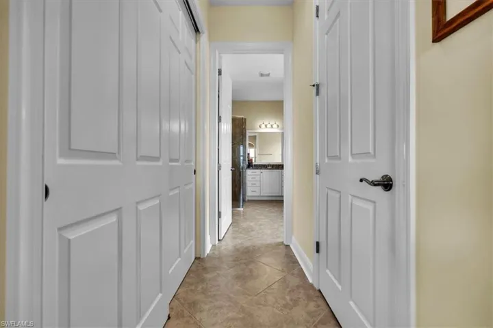 Corridor featuring light tile patterned floors and baseboards