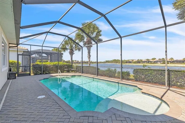 Outdoor pool with a sunroom, a water view, a lanai, and a patio