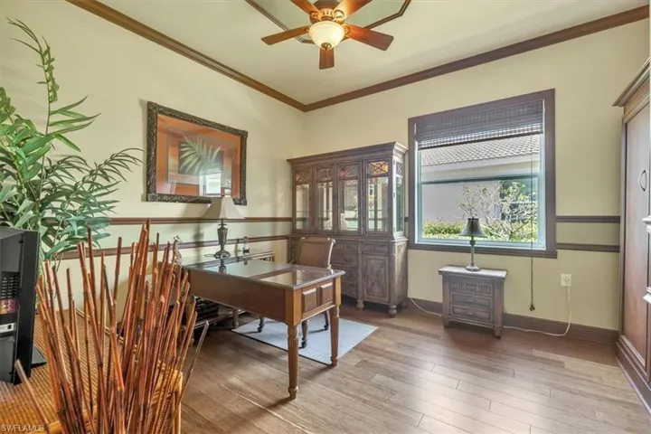 Office space with hardwood / wood-style floors, a ceiling fan, and ornamental molding