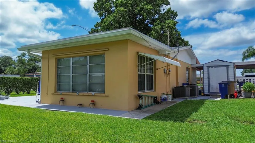 View of home's exterior with a shed, a yard, and stucco siding