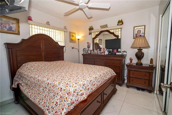 Bedroom with light marble finish floors and a ceiling fan